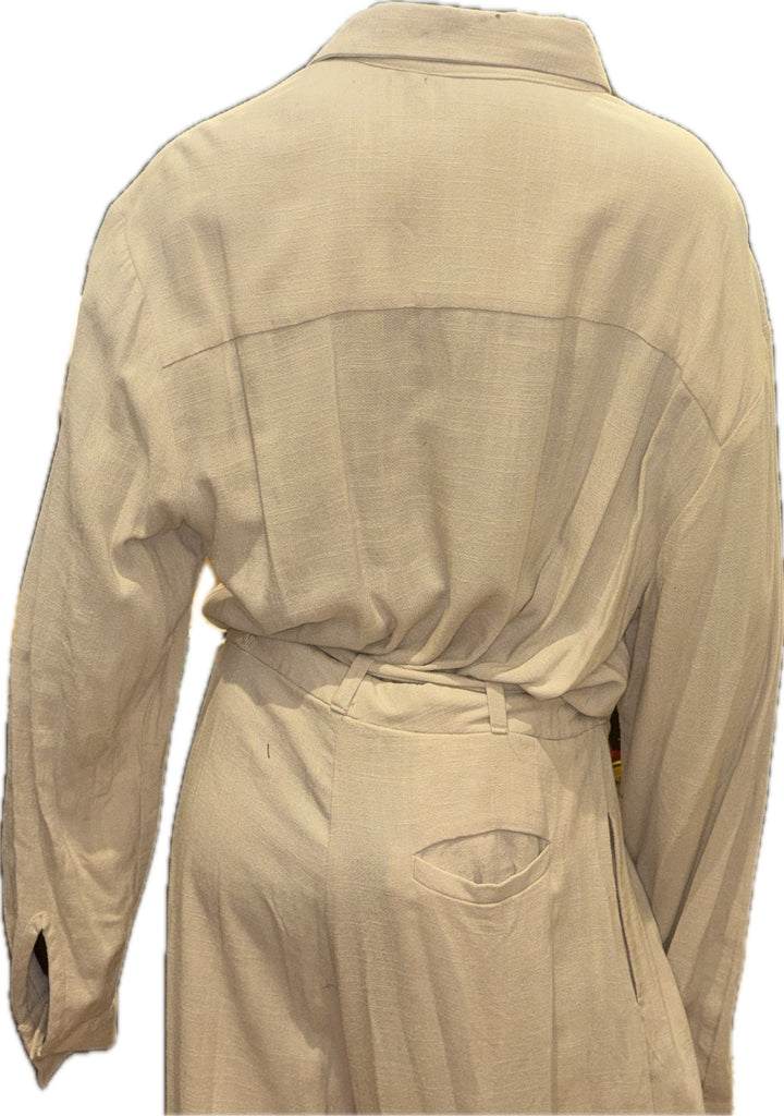 A beige long-sleeve collared shirt or lightweight jacket shown from the back, featuring a tie waist and a back pocket, on a plain white background.